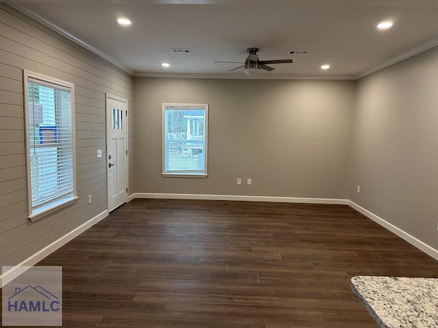 foyer entrance with wooden walls, dark hardwood / wood-style flooring, ceiling fan, and ornamental molding