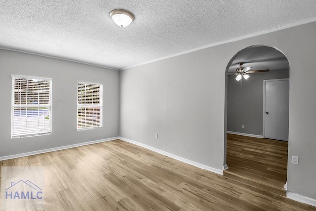 905 Greenbriar Rd, Hinesville, GA 31313 - empty room with arched walkways, a textured ceiling, wood finished floors, ceiling fan, and baseboards
