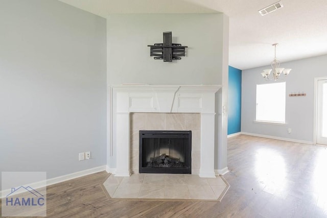 46 Covey Ln NE, Ludowici, GA 31316 - detailed view of wood finished floors, a chandelier, a tiled fireplace, and baseboards