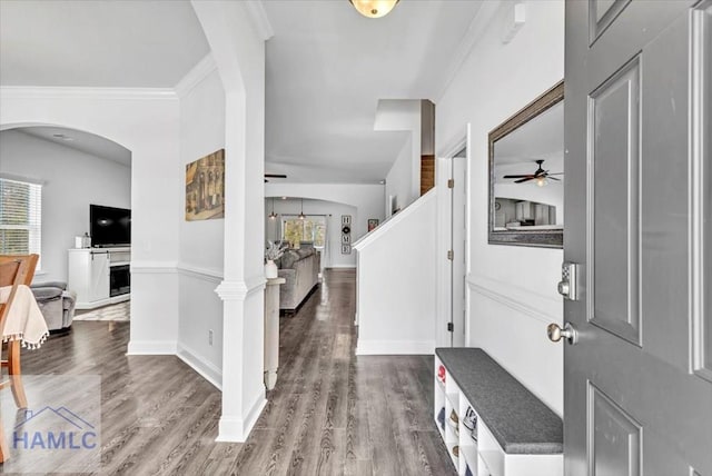 foyer entrance with arched walkways, wood finished floors, and a ceiling fan
