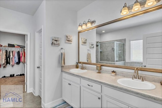 bathroom with double vanity, a sink, a walk in closet, and a shower stall