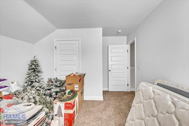 carpeted bedroom with baseboards and vaulted ceiling