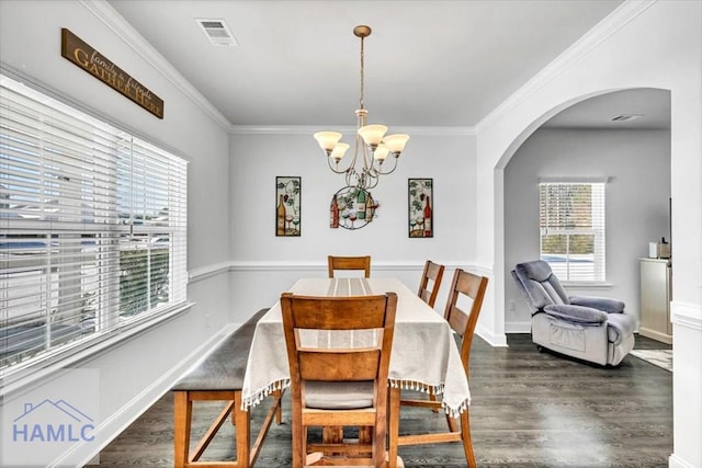 dining area featuring an inviting chandelier, wood finished floors, arched walkways, and visible vents
