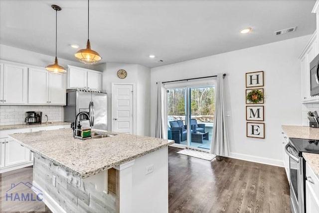 kitchen featuring dark wood-style flooring, stainless steel appliances, backsplash, a sink, and white cabinets
