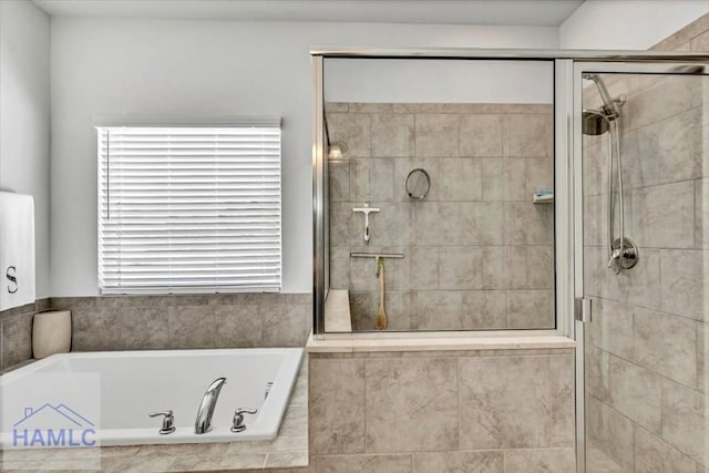 bathroom with a stall shower and a bath