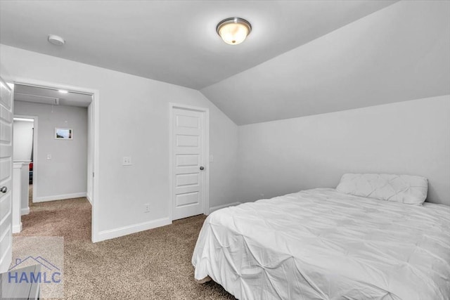 bedroom with baseboards, carpet floors, lofted ceiling, and attic access