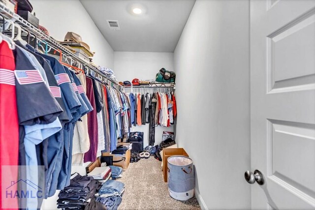 walk in closet with visible vents and carpet