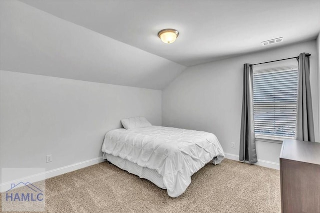 bedroom with baseboards, visible vents, light colored carpet, and vaulted ceiling