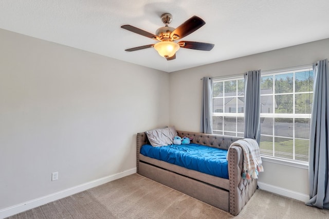 carpeted bedroom with ceiling fan and a textured ceiling