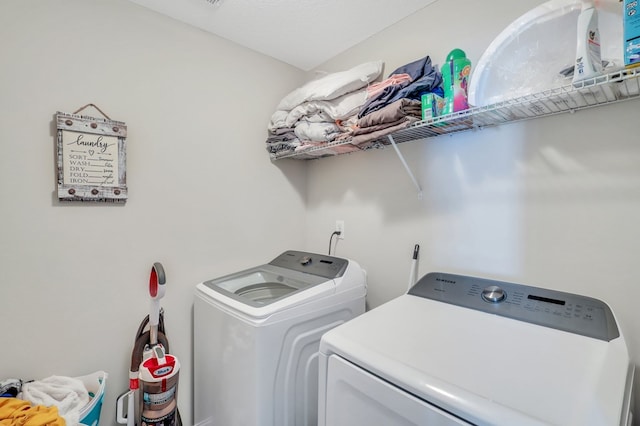 laundry area with independent washer and dryer and a textured ceiling