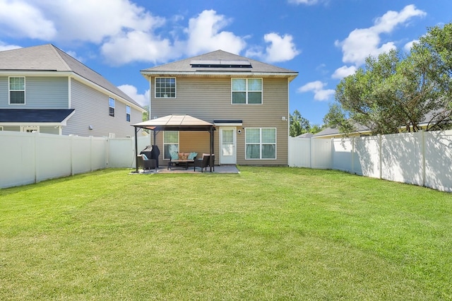 rear view of property with a gazebo, a lawn, an outdoor hangout area, and solar panels