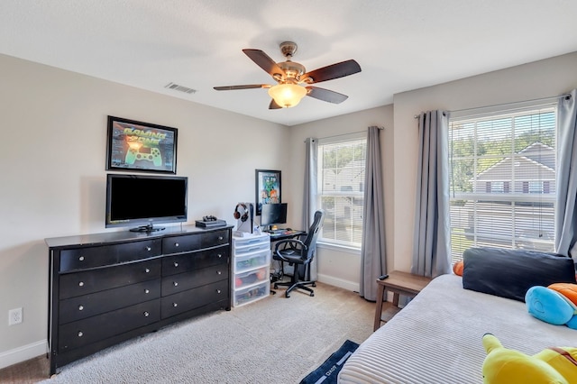 carpeted bedroom featuring multiple windows and ceiling fan