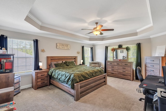 bedroom with a raised ceiling, multiple windows, ceiling fan, and light carpet