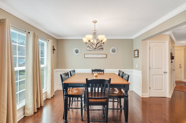 dining space with a textured ceiling, dark hardwood / wood-style floors, crown molding, and a notable chandelier