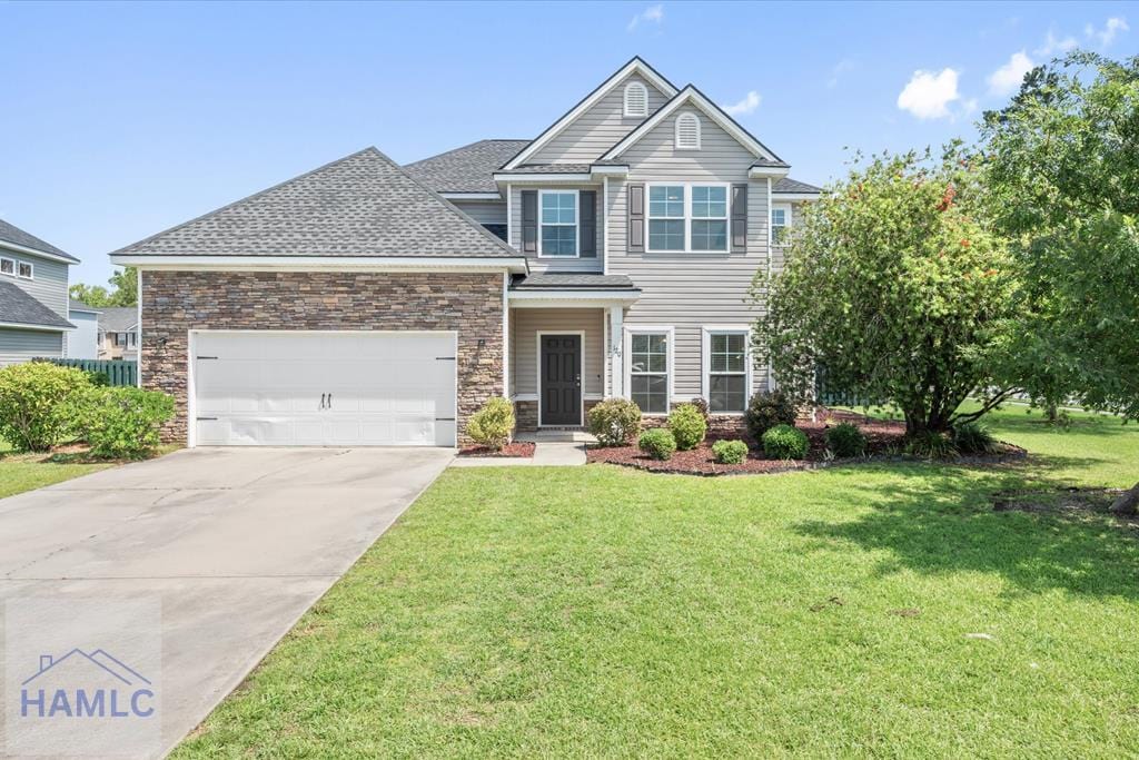 120 Glen Way, Richmond Hill, GA 31324 - view of front facade with a garage, a front lawn, driveway, and stone siding
