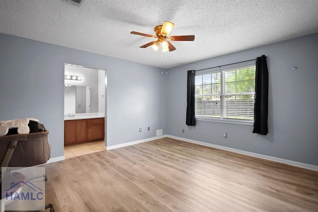926 Poppleton Dr, Hinesville, GA 31313 - unfurnished bedroom with light wood-type flooring, a textured ceiling, a sink, baseboards, and ensuite bath