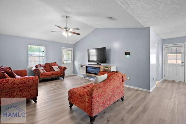 926 Poppleton Dr, Hinesville, GA 31313 - living room with light wood-style floors, ceiling fan, baseboards, lofted ceiling, and a textured ceiling