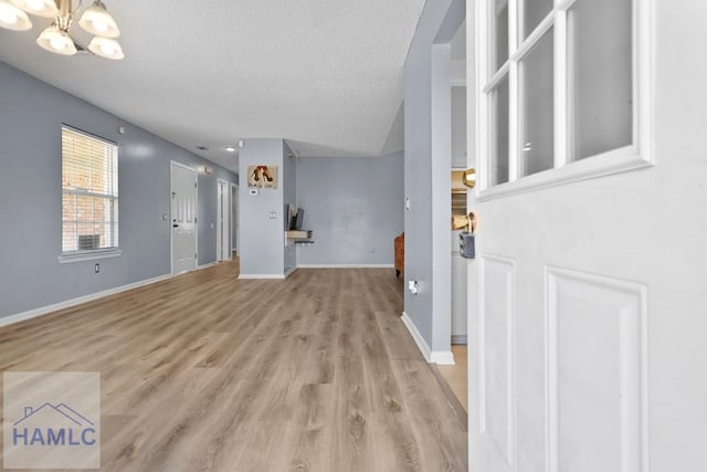 926 Poppleton Dr, Hinesville, GA 31313 - foyer entrance featuring a textured ceiling, a chandelier, light wood-style flooring, and baseboards