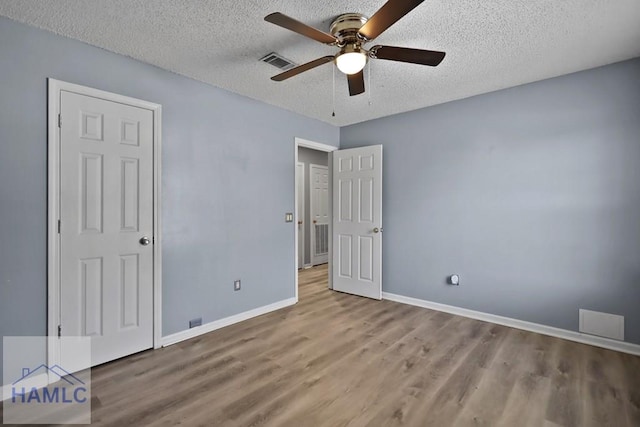 926 Poppleton Dr, Hinesville, GA 31313 - unfurnished bedroom featuring wood finished floors, a textured ceiling, baseboards, and a ceiling fan