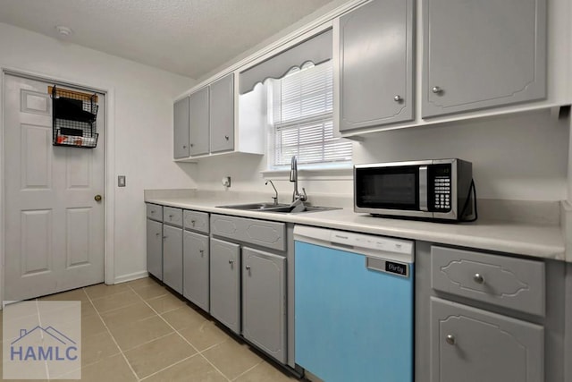 926 Poppleton Dr, Hinesville, GA 31313 - kitchen featuring dishwashing machine, stainless steel microwave, gray cabinetry, a sink, and light tile patterned floors