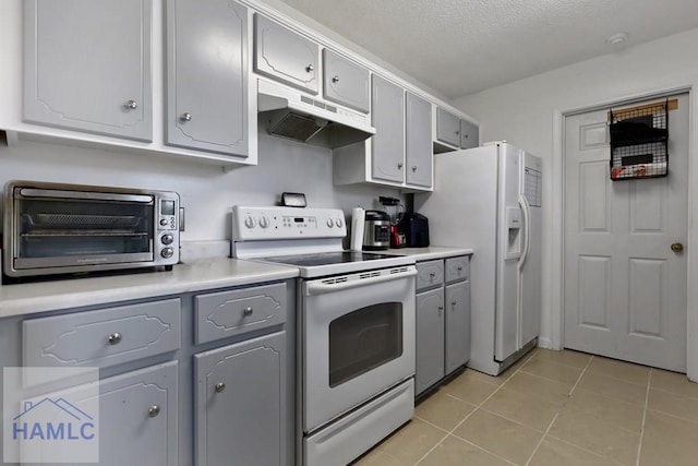926 Poppleton Dr, Hinesville, GA 31313 - kitchen with white appliances, under cabinet range hood, gray cabinets, light tile patterned flooring, and light countertops