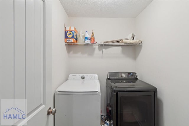 laundry room featuring washer and dryer and a textured ceiling