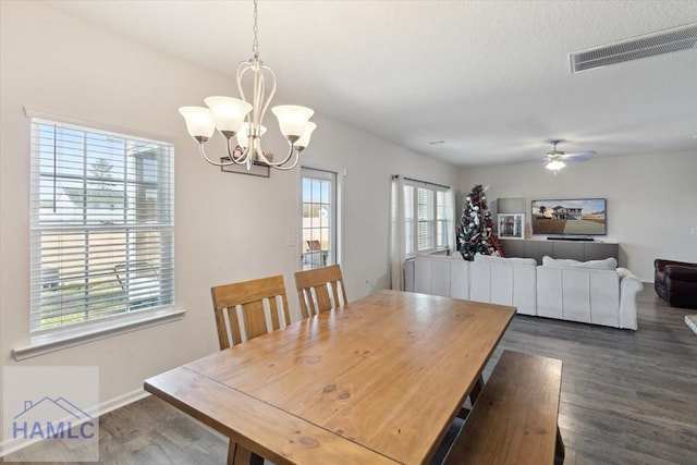 dining area featuring ceiling fan with notable chandelier and dark hardwood / wood-style flooring