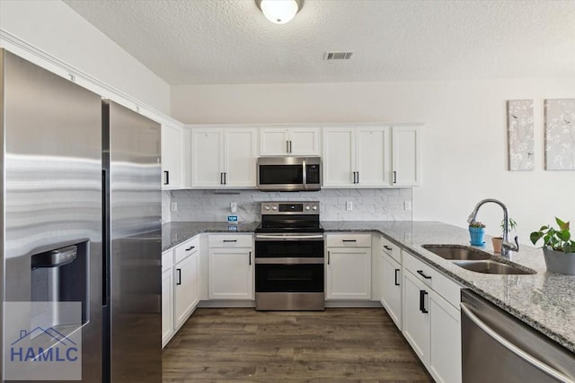 kitchen featuring light stone counters, sink, white cabinetry, and stainless steel appliances