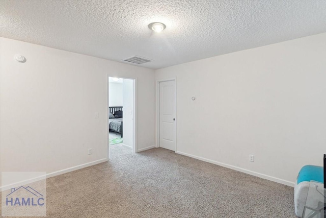 carpeted spare room featuring a textured ceiling