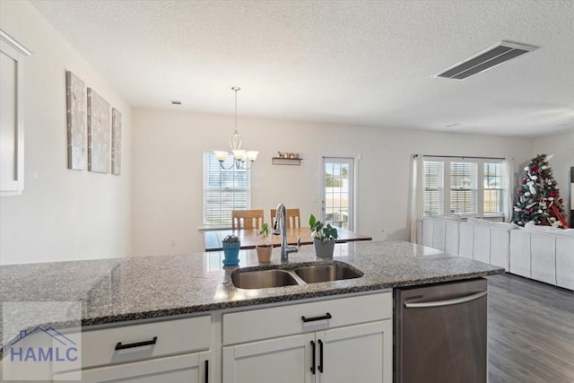 kitchen with dishwasher, sink, white cabinets, and stone countertops