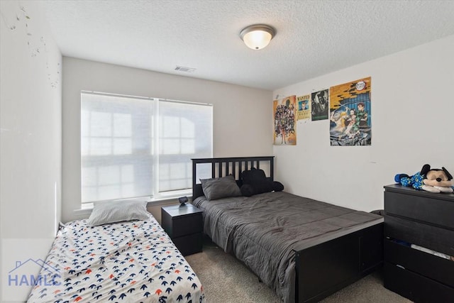 bedroom with light colored carpet and a textured ceiling