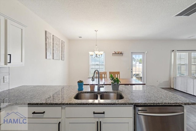 kitchen featuring a textured ceiling, white cabinetry, dark stone countertops, and sink