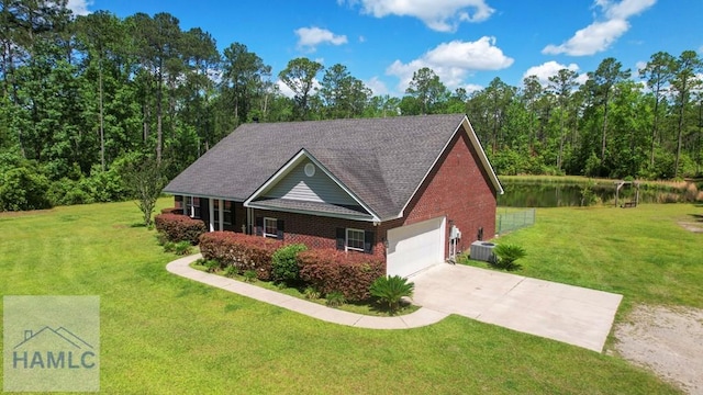 1653 Hawthorne Rd, Townsend, GA 31331 - view of front facade with brick siding, driveway, a water view, an attached garage, and a front lawn