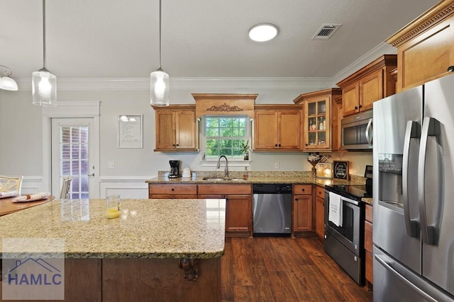 1653 Hawthorne Rd, Townsend, GA 31331 - kitchen featuring appliances with stainless steel finishes, a sink, brown cabinetry, ornamental molding, and light stone countertops