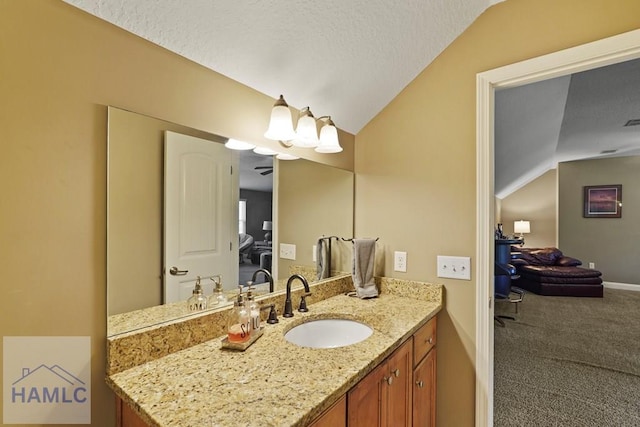 1653 Hawthorne Rd, Townsend, GA 31331 - bathroom featuring vaulted ceiling, vanity, baseboards, a textured ceiling, and ensuite bath