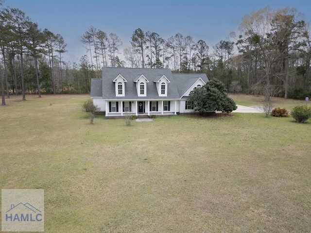 cape cod house with a front yard, covered porch, and a shingled roof