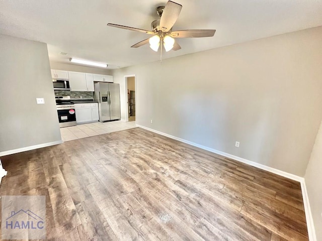 unfurnished living room featuring ceiling fan and light wood-type flooring