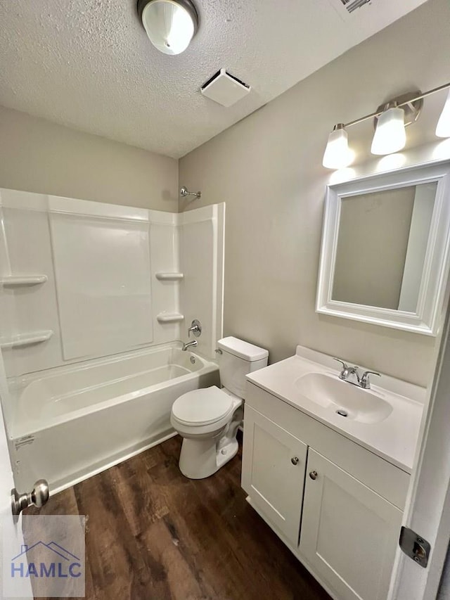 full bathroom featuring a textured ceiling, vanity, shower / bathing tub combination, hardwood / wood-style floors, and toilet