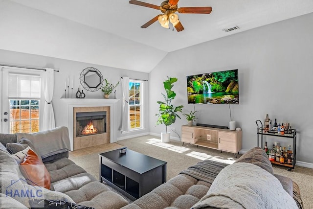 carpeted living room with a fireplace, ceiling fan, and lofted ceiling