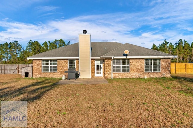 rear view of house with a patio and a lawn