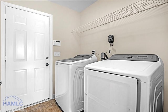 laundry area with washing machine and dryer and dark tile patterned flooring