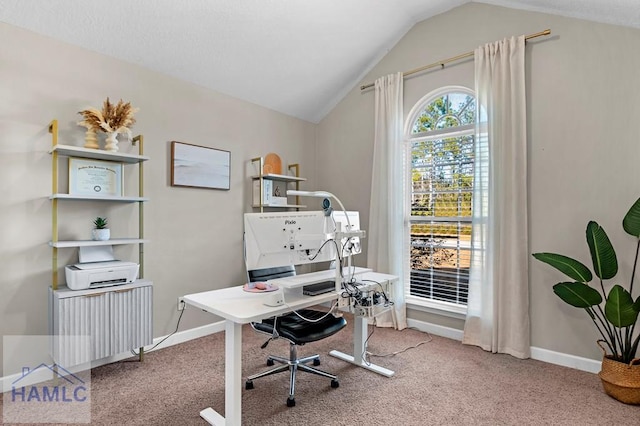 carpeted home office featuring vaulted ceiling