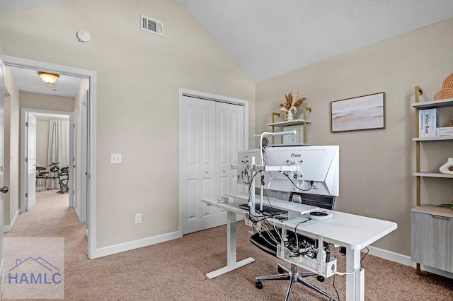 carpeted home office featuring vaulted ceiling