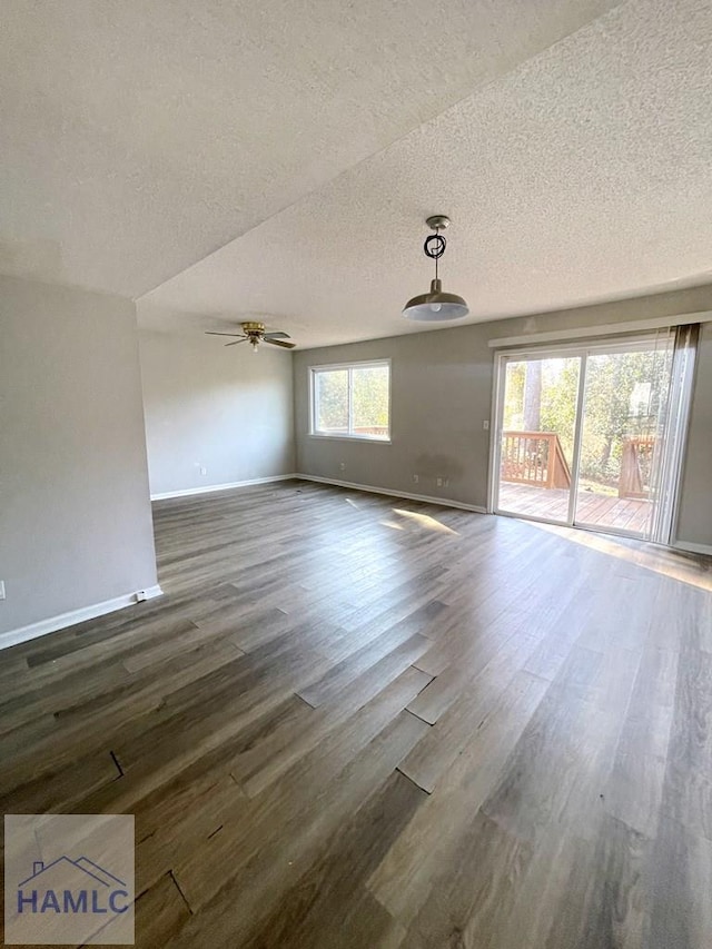 interior space with a textured ceiling, dark hardwood / wood-style floors, and ceiling fan