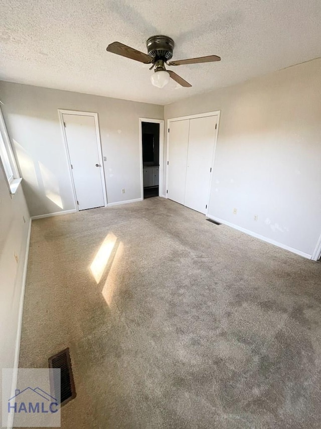 unfurnished bedroom featuring carpet flooring, ceiling fan, a textured ceiling, and a closet