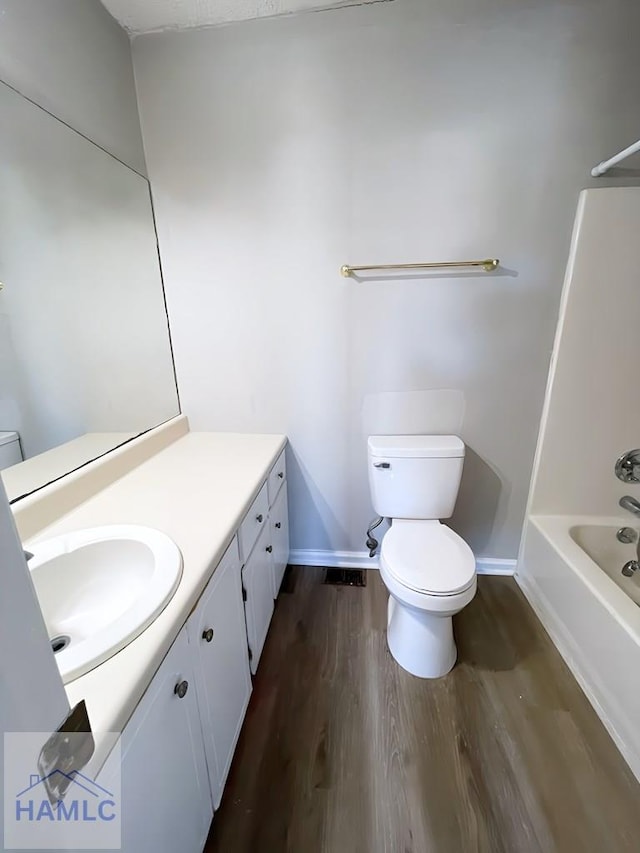 full bathroom featuring hardwood / wood-style floors, vanity, toilet, and bathtub / shower combination