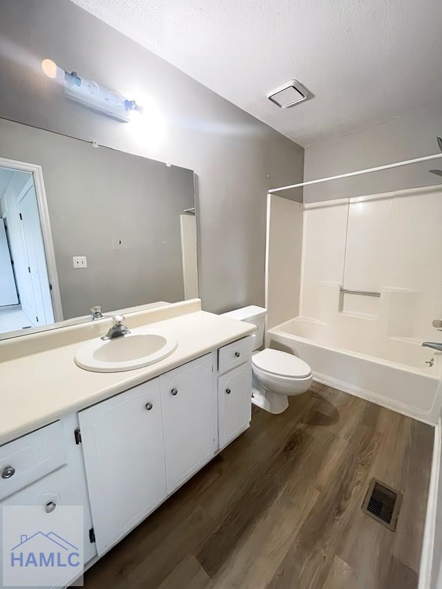 full bathroom with toilet, vanity, bathtub / shower combination, and hardwood / wood-style flooring