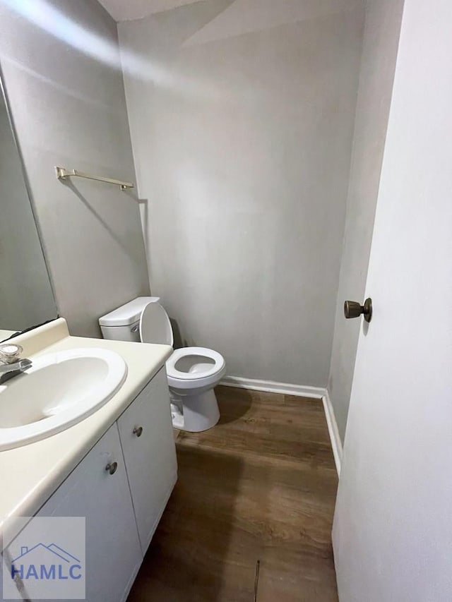 bathroom with hardwood / wood-style floors, vanity, and toilet