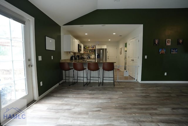 21 Oak Ridge Cemetery Rd SW, Ludowici, GA 31316 - kitchen with stainless steel refrigerator with ice dispenser, vaulted ceiling, a peninsula, healthy amount of natural light, and light wood-style floors