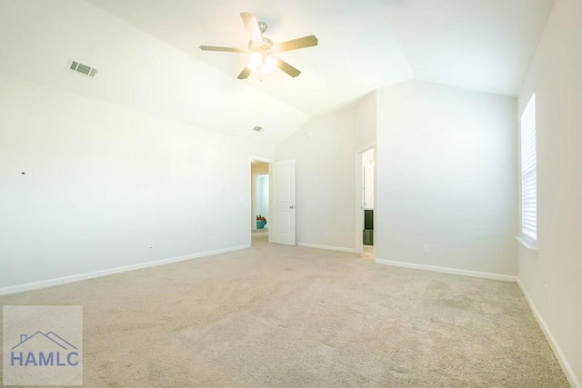 carpeted empty room with ceiling fan and lofted ceiling